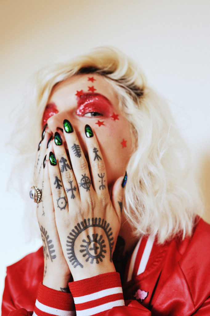 Artist OKO showing her sicanje tattoos